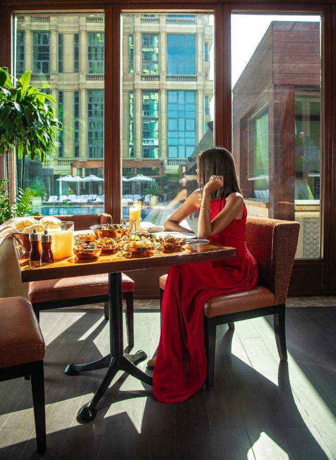 Four Seasons Cairo At The First Residence Giza Dış mekan fotoğraf A woman dining at a restaurant